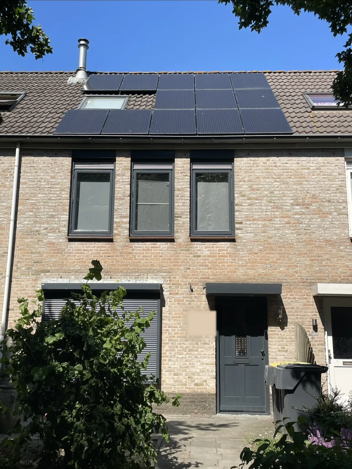 De echte voorzijde van ons huis met zonnepanelen op het dak